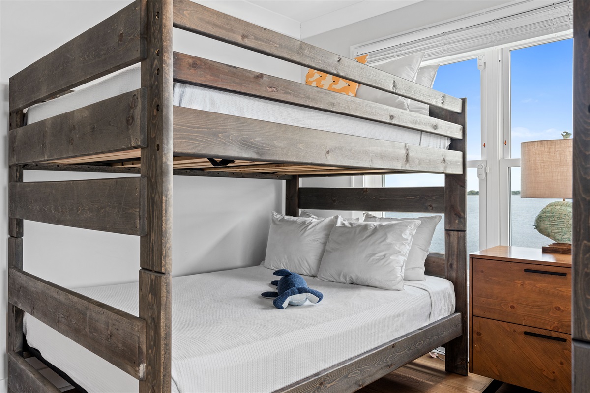 Comfortable queen bunk beds offer stylish sleeping arrangements with beautiful natural light and water views