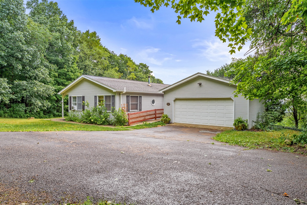 Tucked into the trees, this inviting ranch offers a peaceful escape with a private driveway and attached garage