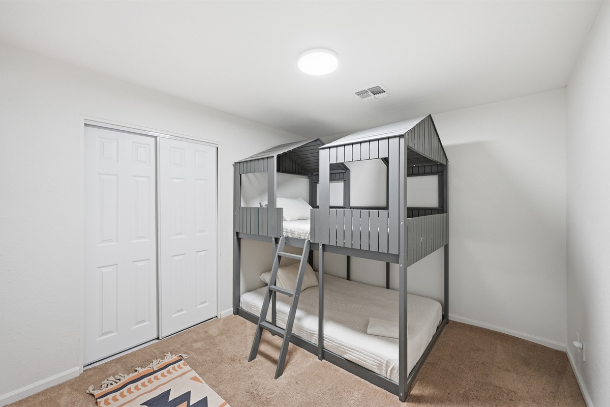Designed with little adventurers in mind, this fun bunk room features a custom cabin-style frame and cozy bedding for the perfect sleepover vibe.