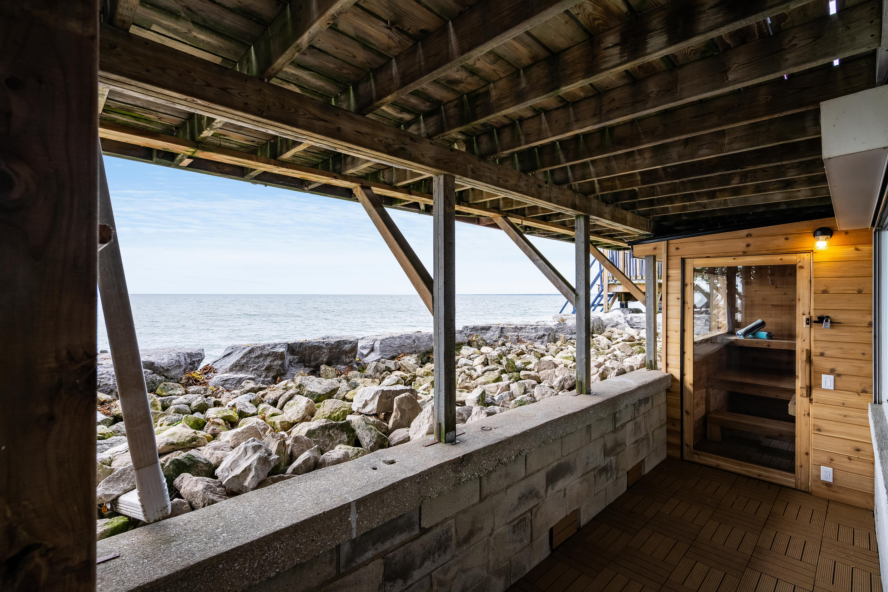 Covered outdoor sauna with stunning views of the rocky shoreline.