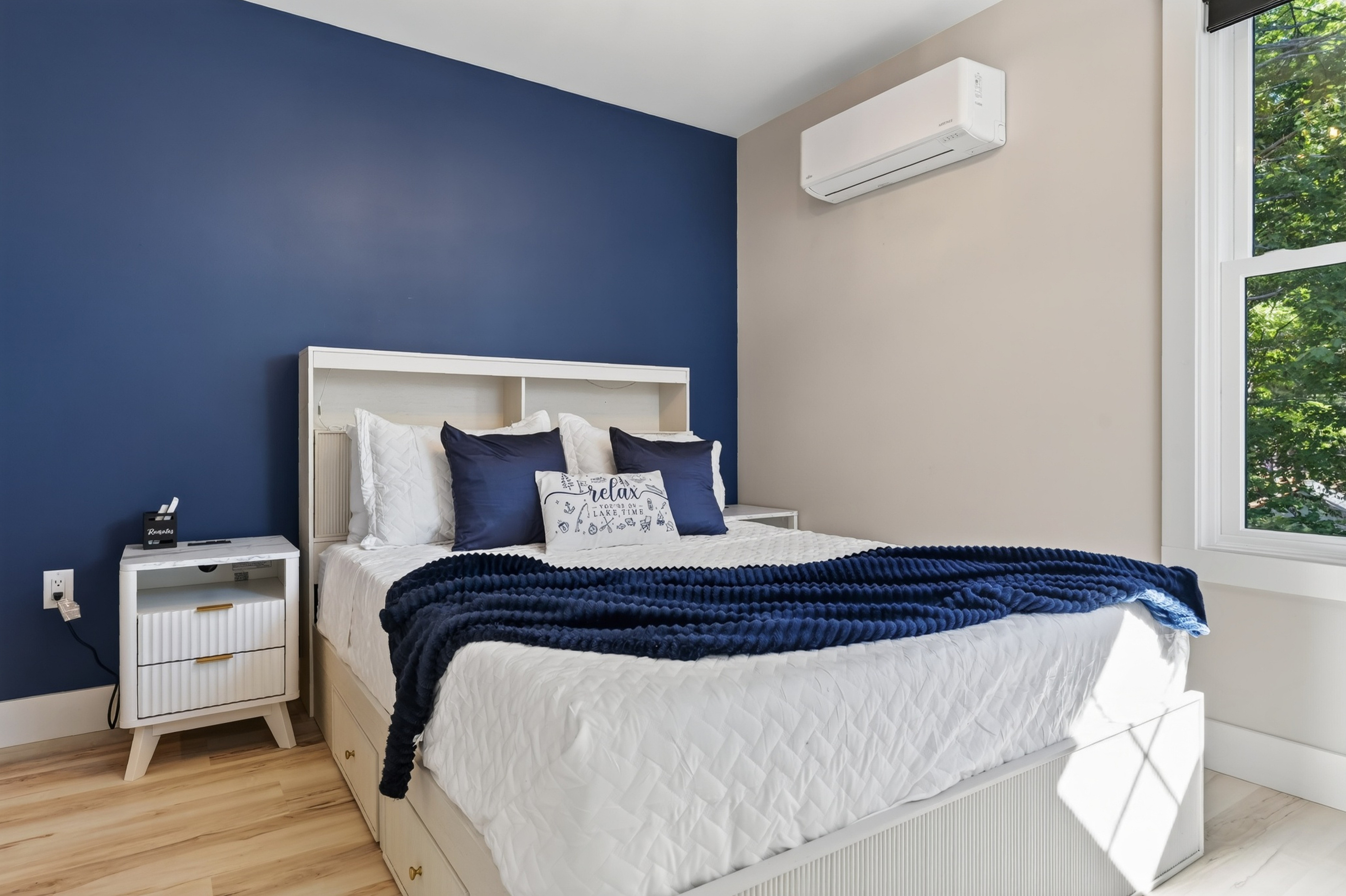 Rich navy tones give this queen room a polished, cozy feel that is easy to settle into.