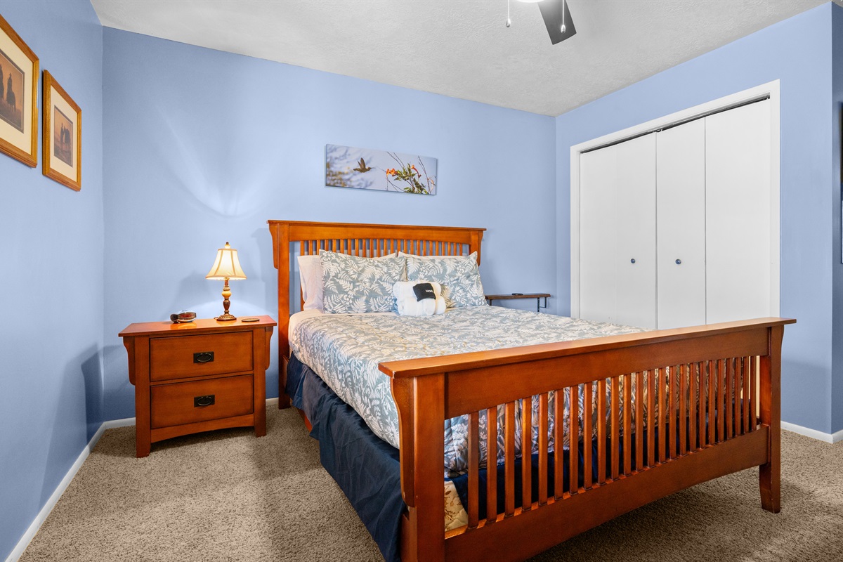 Second bedroom featuring a queen bed, comfortable linens, and mountain-inspired décor.