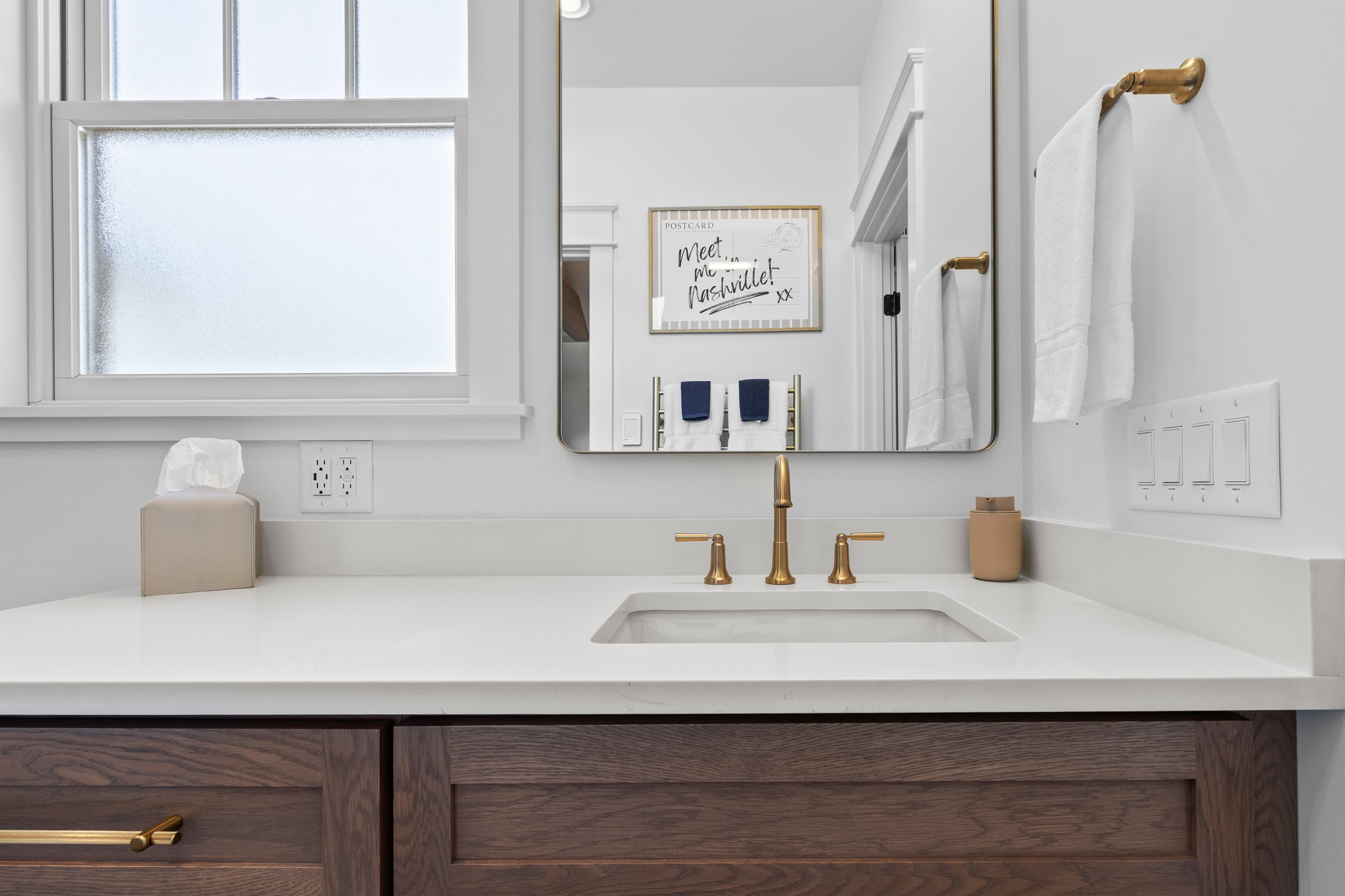 Bright bathroom with generous counter space and a playful “easter egg” artwork.
