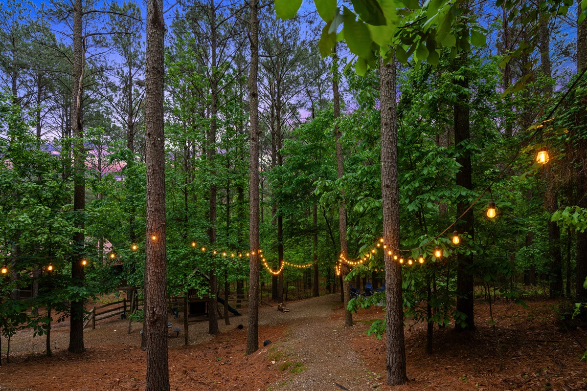 Soft string lighting throughout the trees creates a warm and slightly magical feel as the sun goes down.