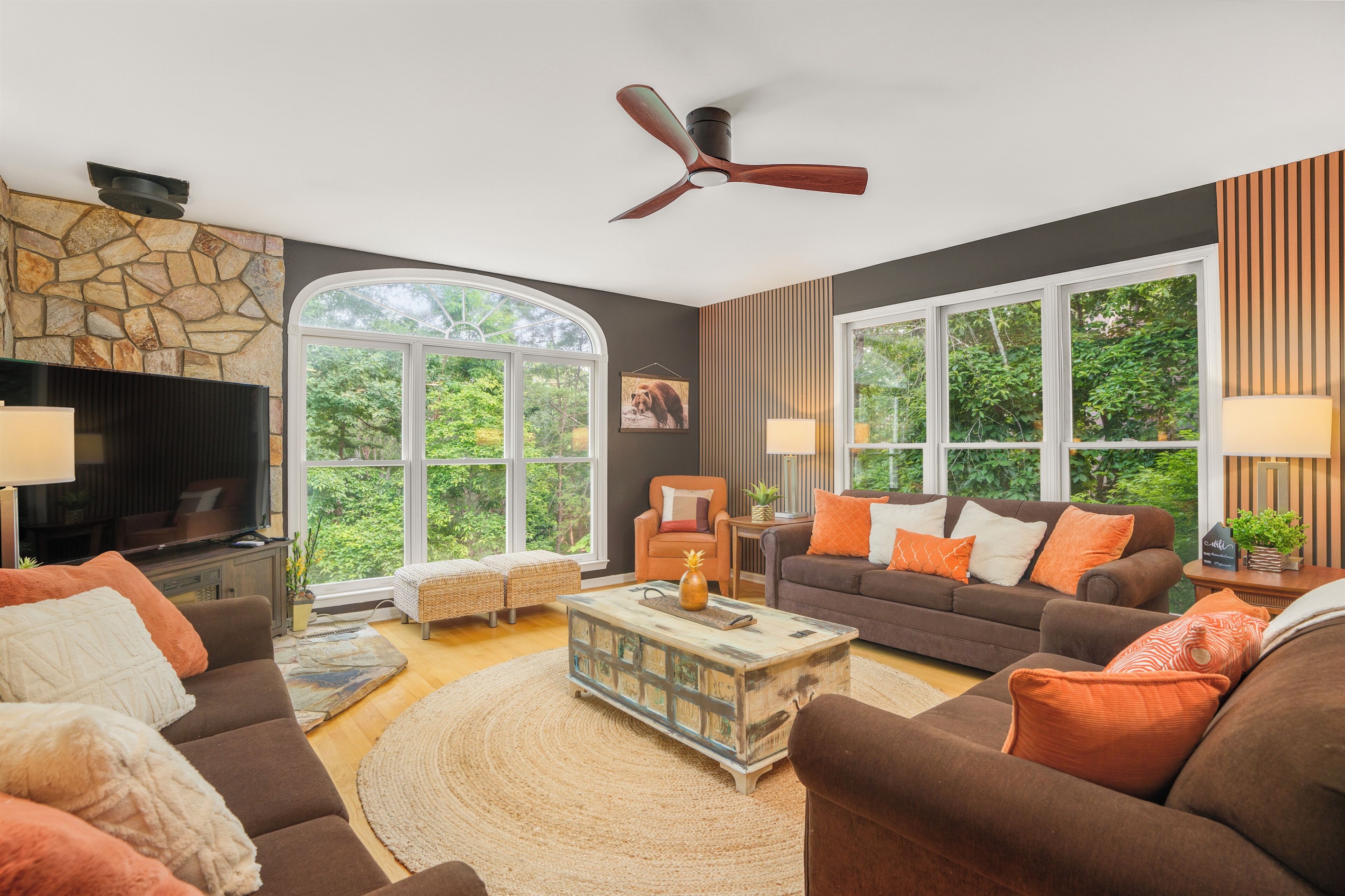 Living room with large TV, electric fireplace, and ample seating
