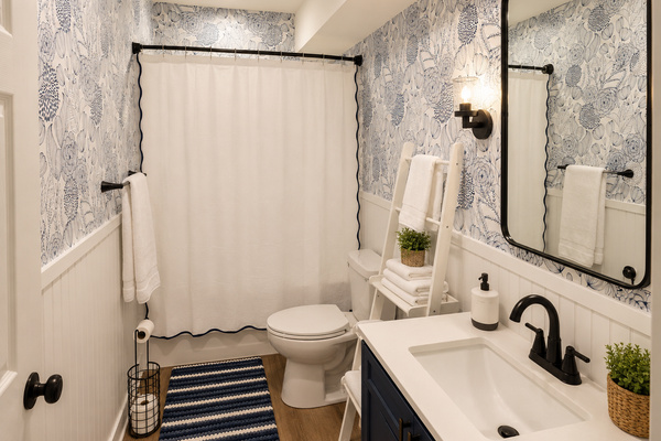 Main-floor bathroom with tub/shower combo, stocked essentials and convenient access from the nearby bedroom and hallway.