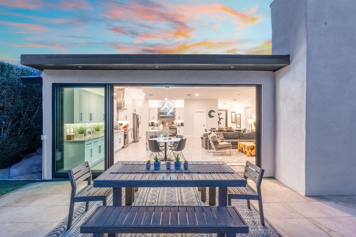 Open the massive sliding glass doors to connect the elegant kitchen and living areas to the stylish backyard dining space.