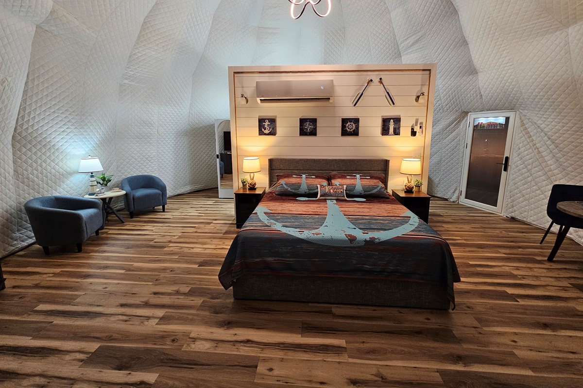 Spacious, beautifully lit dome interior featuring a king bed, cozy seating area, and soaring quilted walls for the perfect romantic retreat