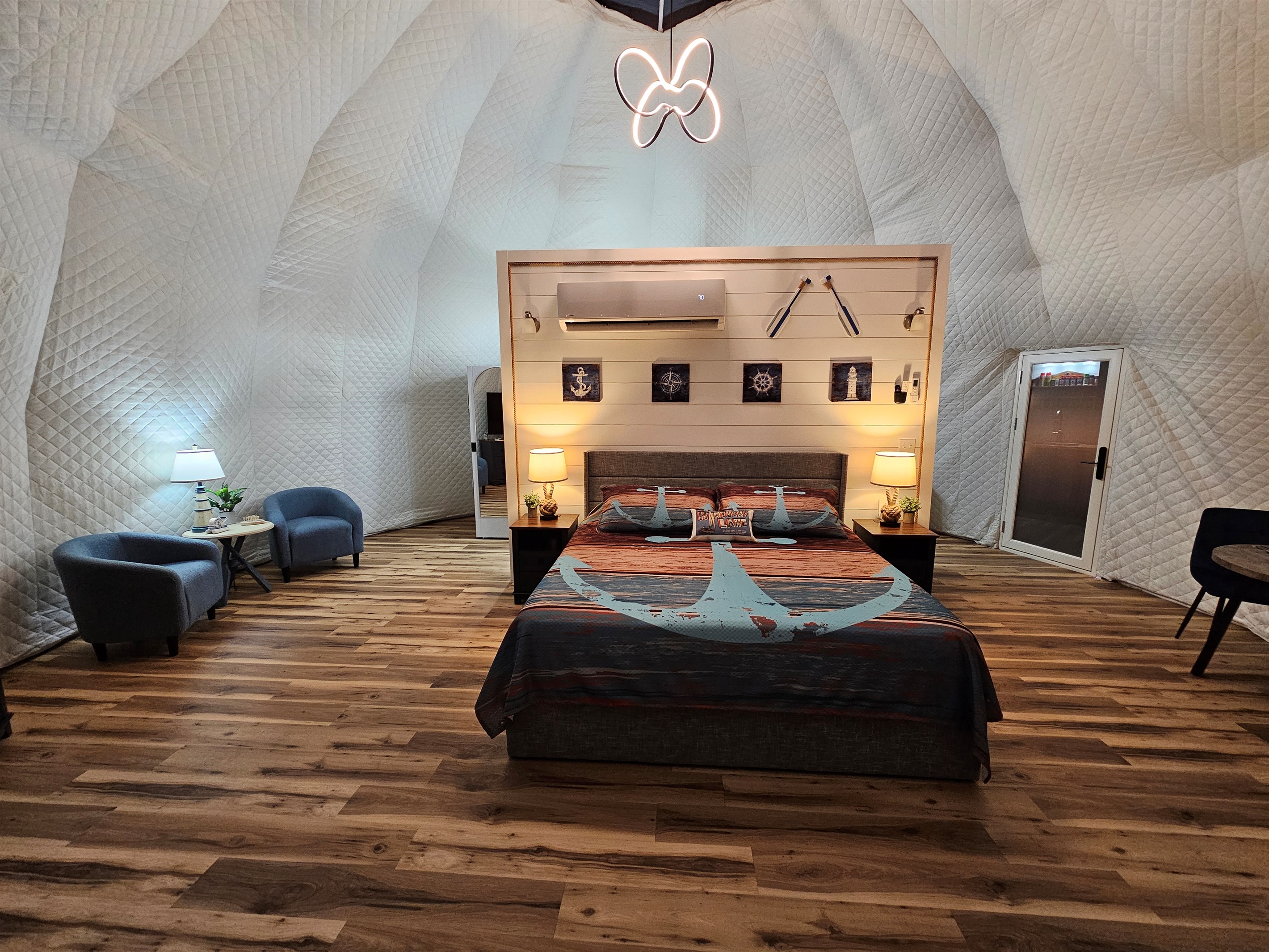 Spacious, beautifully lit dome interior featuring a king bed, cozy seating area, and soaring quilted walls for the perfect romantic retreat