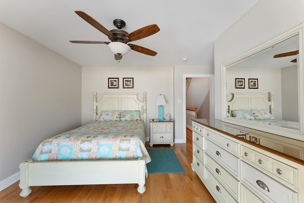 Bedroom offers a full size bed, dresser for storage, an attached bathroom and private access to a covered deck with beautiful views of the ocean. 