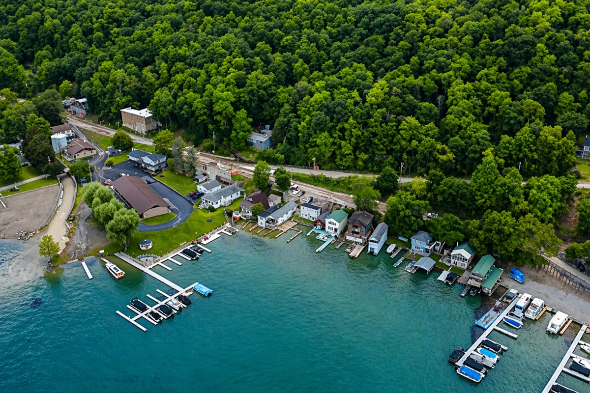 Aerial view of lakeside homes, docks, and lush greenery, offering peaceful water access. 🌊🏡🚤