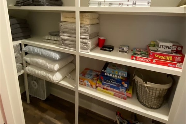 Closet in kid room with games and extra towels.