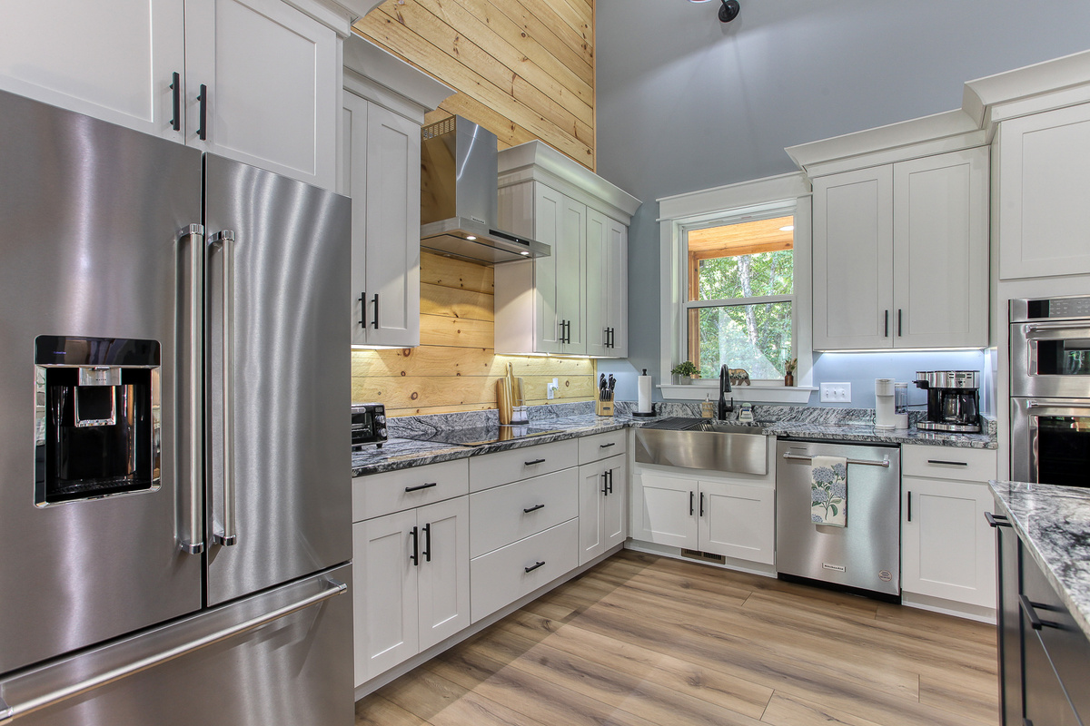 The kitchen at Robbin’s Nest on Snowbird Creek combines warm wood accents with modern conveniences, including a full-size refrigerator and dishwasher.