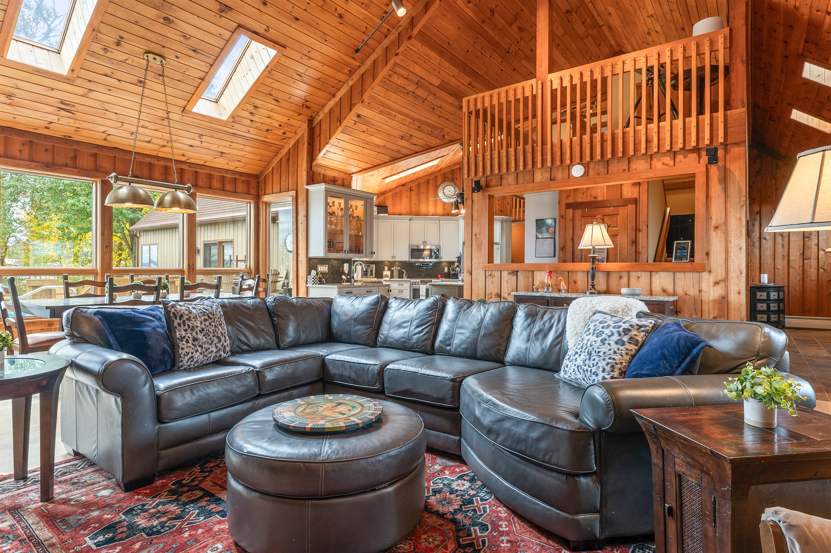Inviting family room with wrap-around sofa and high wood ceilings — a relaxing hub for game nights and movie marathons