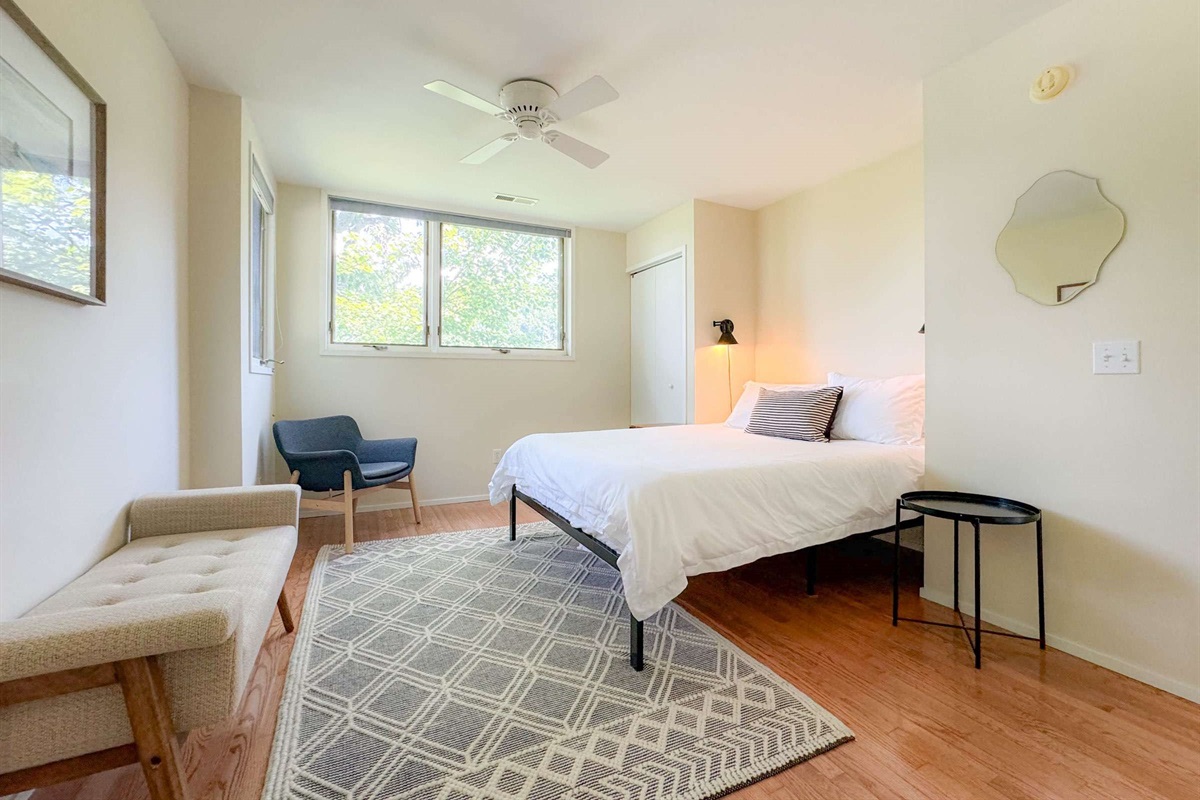 The 2nd bedroom upstairs features a comfy queen size bed and very spacious room. This is the largest bedroom in the house. This bedroom is also complete with plenty of natural light and has a treetop feel.