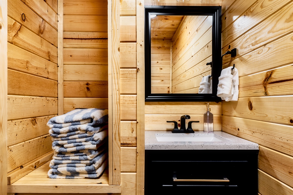 Enjoy the perfect blend of charm and contemporary design in the bathroom, highlighted by its wooden walls and a beautifully crafted sink.