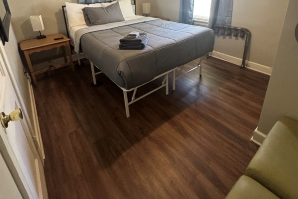 Bedroom number 1 with Queen bed with Smart TV and seat area. 