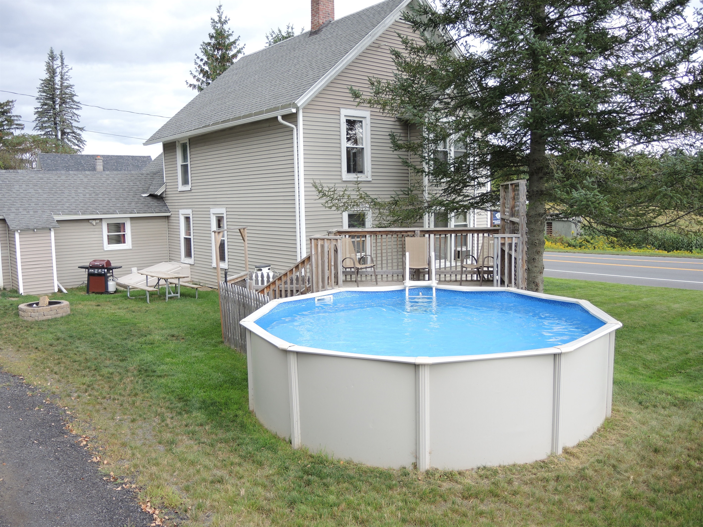 Pool in side yard, with fire pit beyond