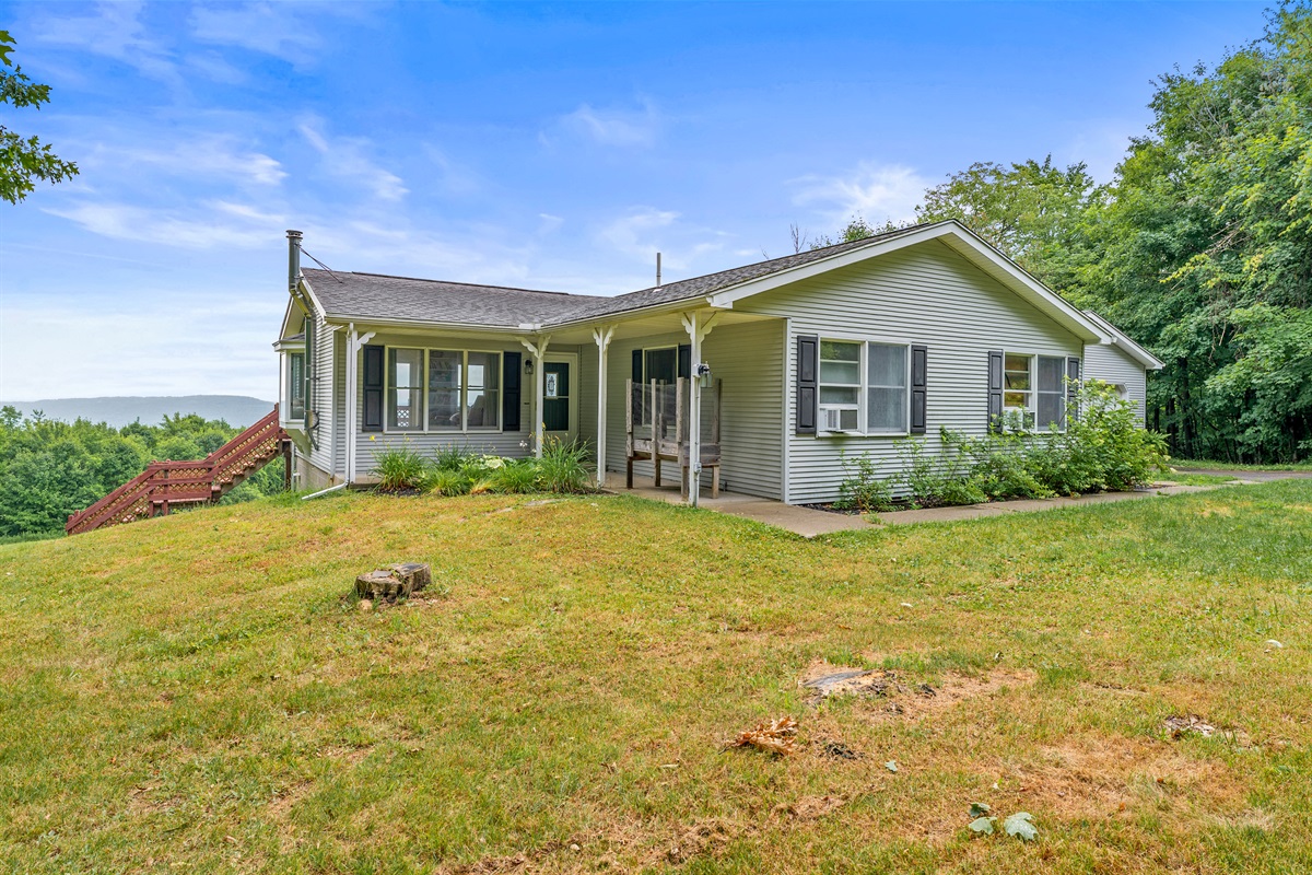Enjoy serene country living in this charming ranch with inviting curb appeal, nestled against a lush wooded backdrop