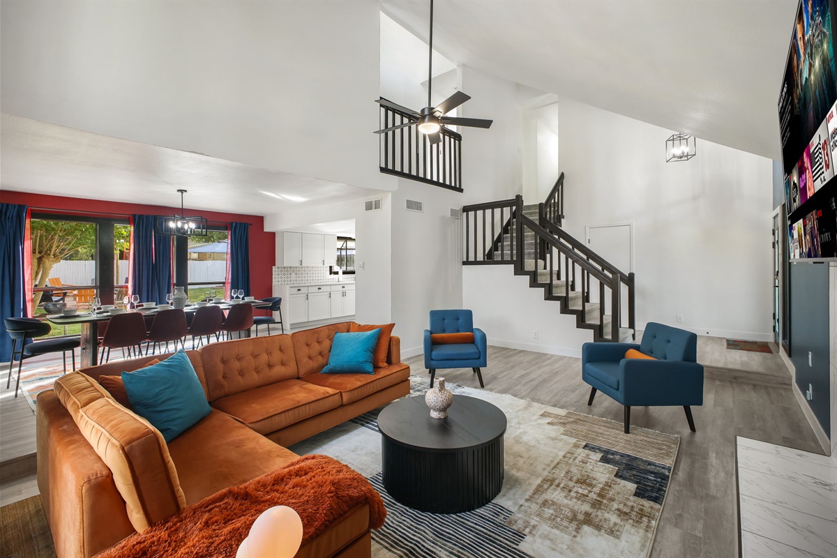 Cozy orange velvet sofa and blue armchairs, perfect for movie nights. Please note: The living room fireplace is decorative only. For a real fire, enjoy the cozy outdoor fire pit!