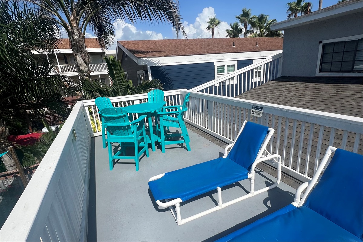 Bar height table and chairs on upper deck with lounge chairs for relaxing or soaking up a little sun. 
