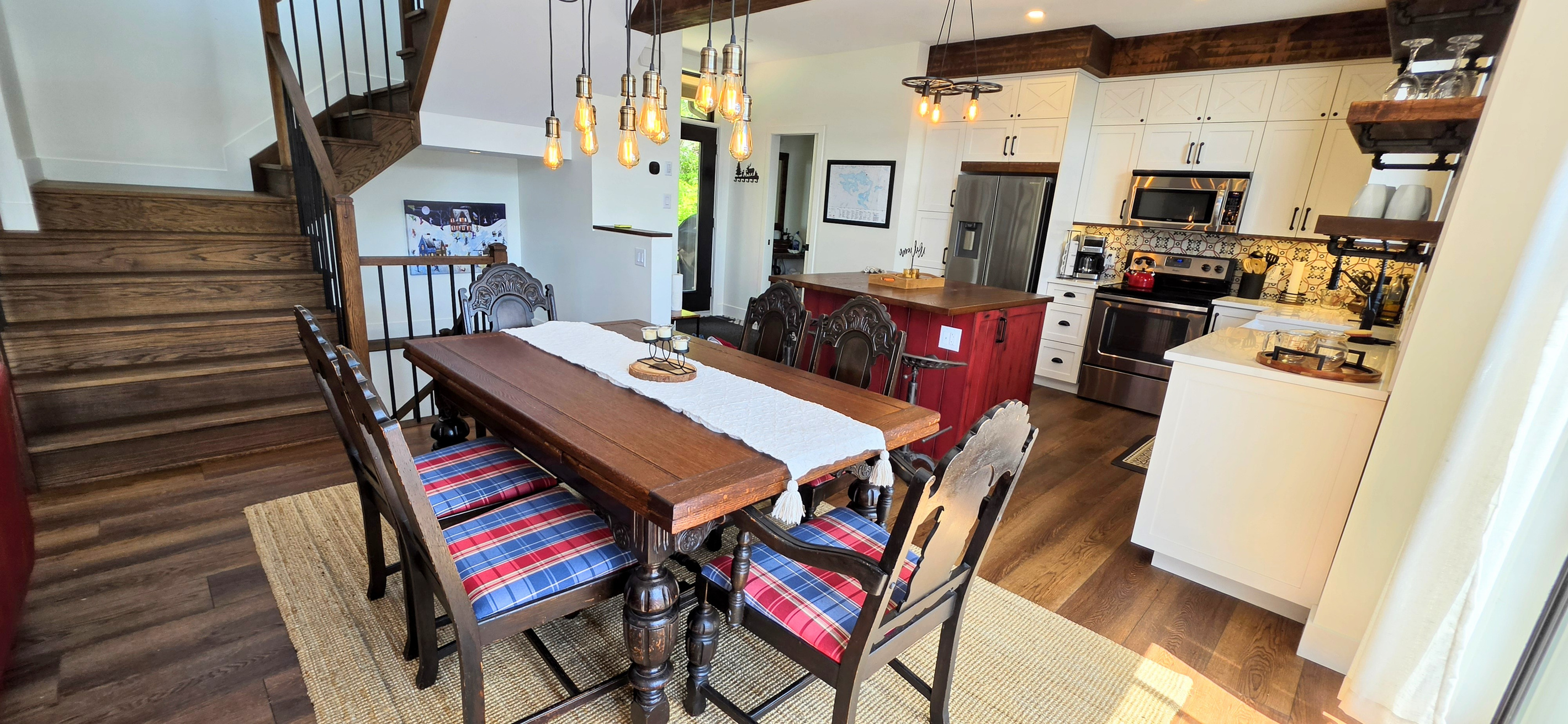 Dining room with adjacent kitchen island and view towards cottage front door