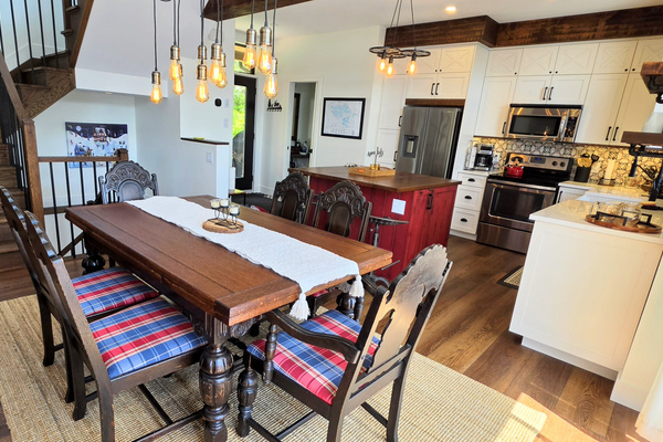 Dining room with adjacent kitchen island and view towards cottage front door