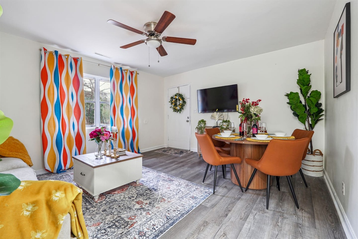 Enjoy a warm and inviting dining area combined with the living room, featuring a dining table set where you can enjoy meals while watching TV. The space also includes a ceiling fan for extra comfort and a cozy atmosphere for gathering and relaxing.
