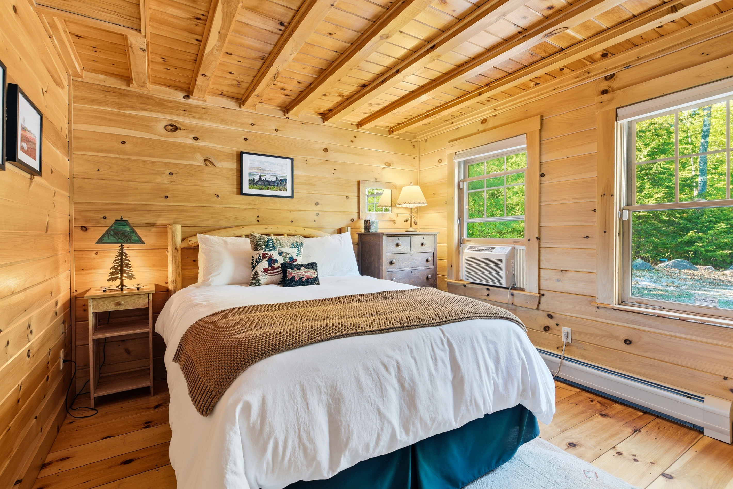 Rest comfortably in this inviting bedroom featuring warm wood interiors and peaceful surroundings.