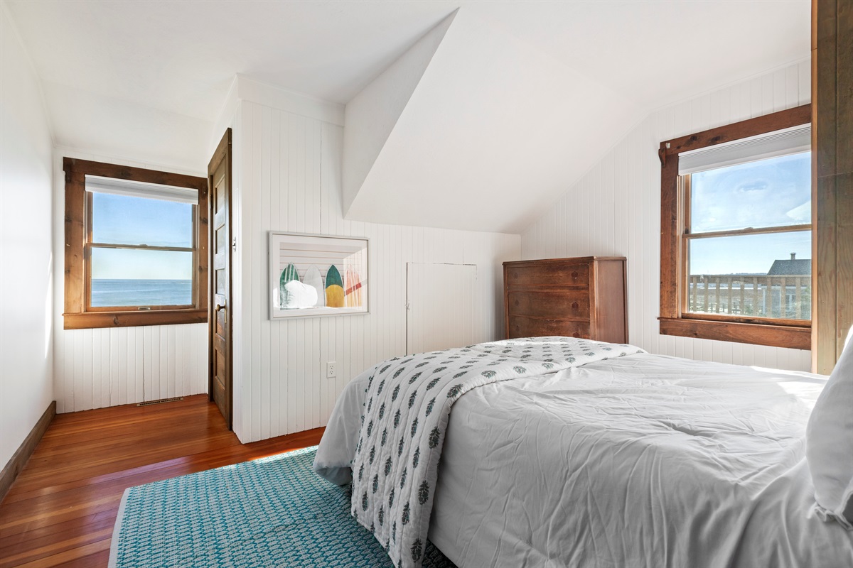Relax in this charming oceanfront bedroom with a cozy full bed and water views.