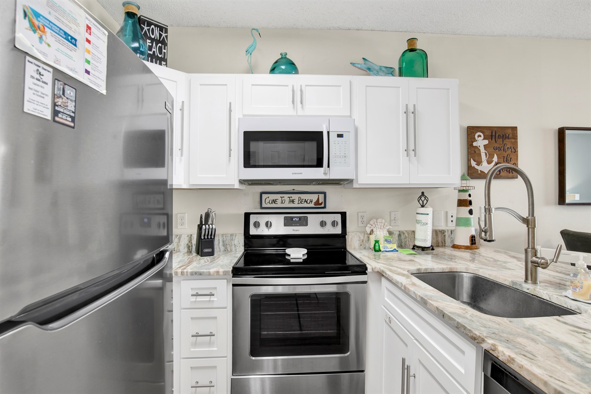 Kitchen with stainless steel appliances, granite tops and beautiful gulf view.