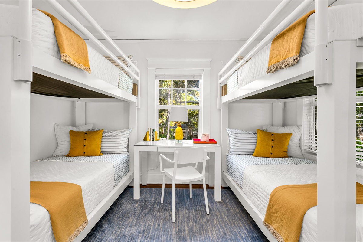 Bright and airy bunk bed bedroom featuring two new durable twin XL bunk beds, modern artwork, and a personal desk and chair—ideal for remote work. Enjoy a smart TV and peaceful views overlooking the quiet Flamingo Park street.