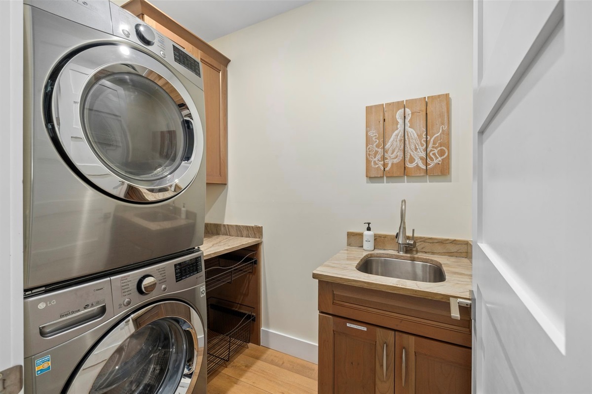 Laundry room with washer, dryer, and utility sink for guest use