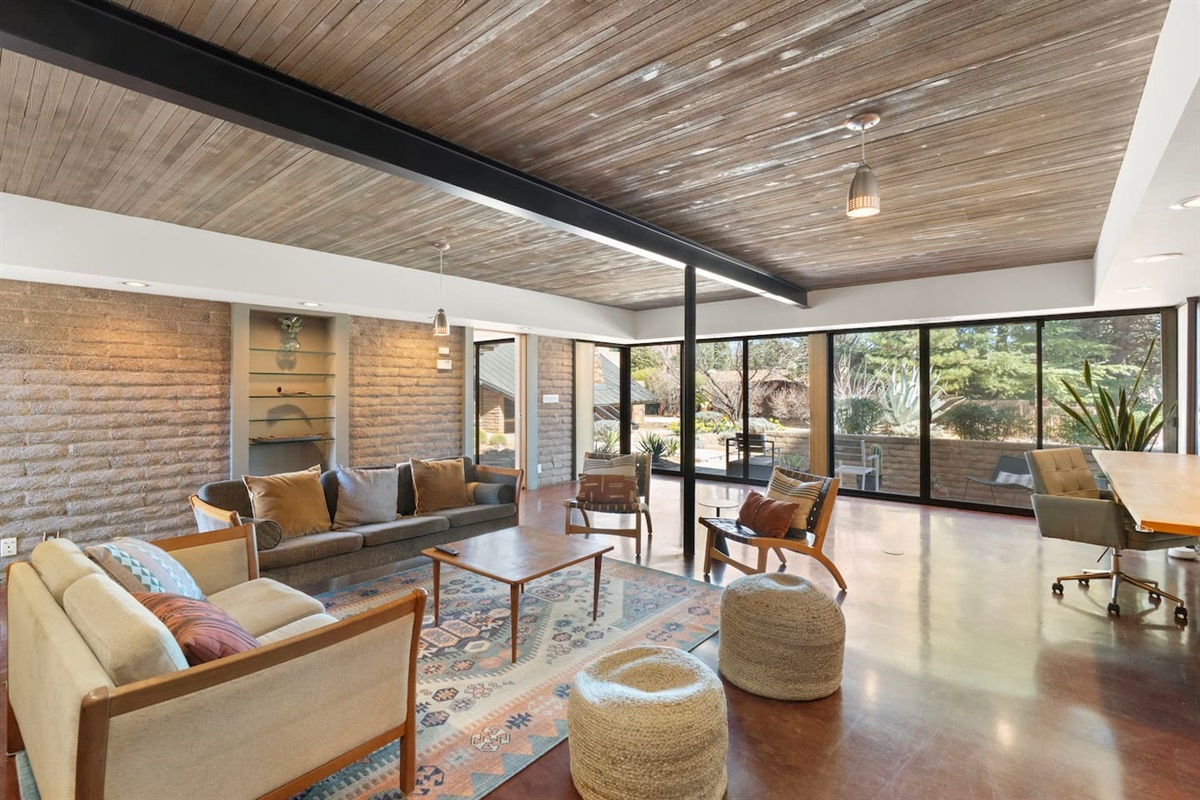 Open-concept living area with floor-to-ceiling windows and seamless indoor-outdoor flow.