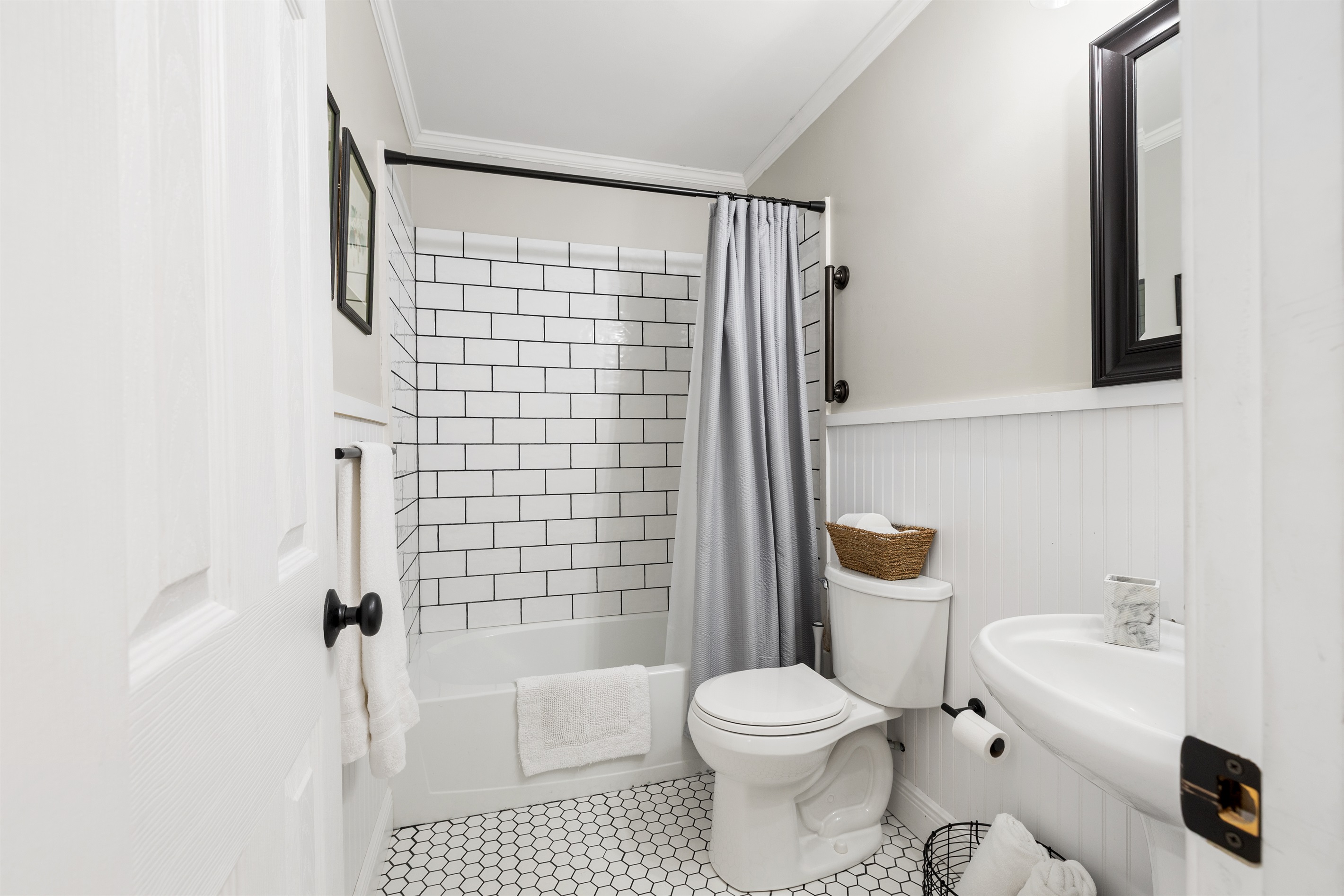 A bright, farmhouse-style bathroom with a tub/shower combo