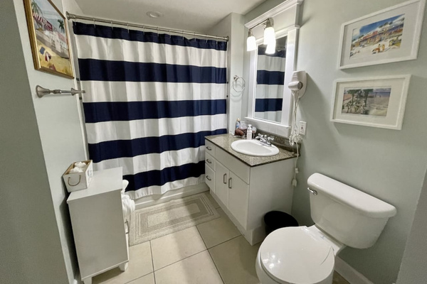 Bathroom with tub and shower, opens to hallway and second bedroom