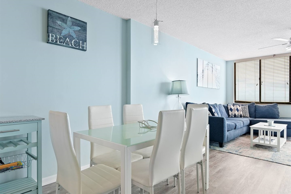An elegant dining area featuring a sleek white table and chairs, exuding sophistication and charm—perfect for hosting meals and creating memorable moments.