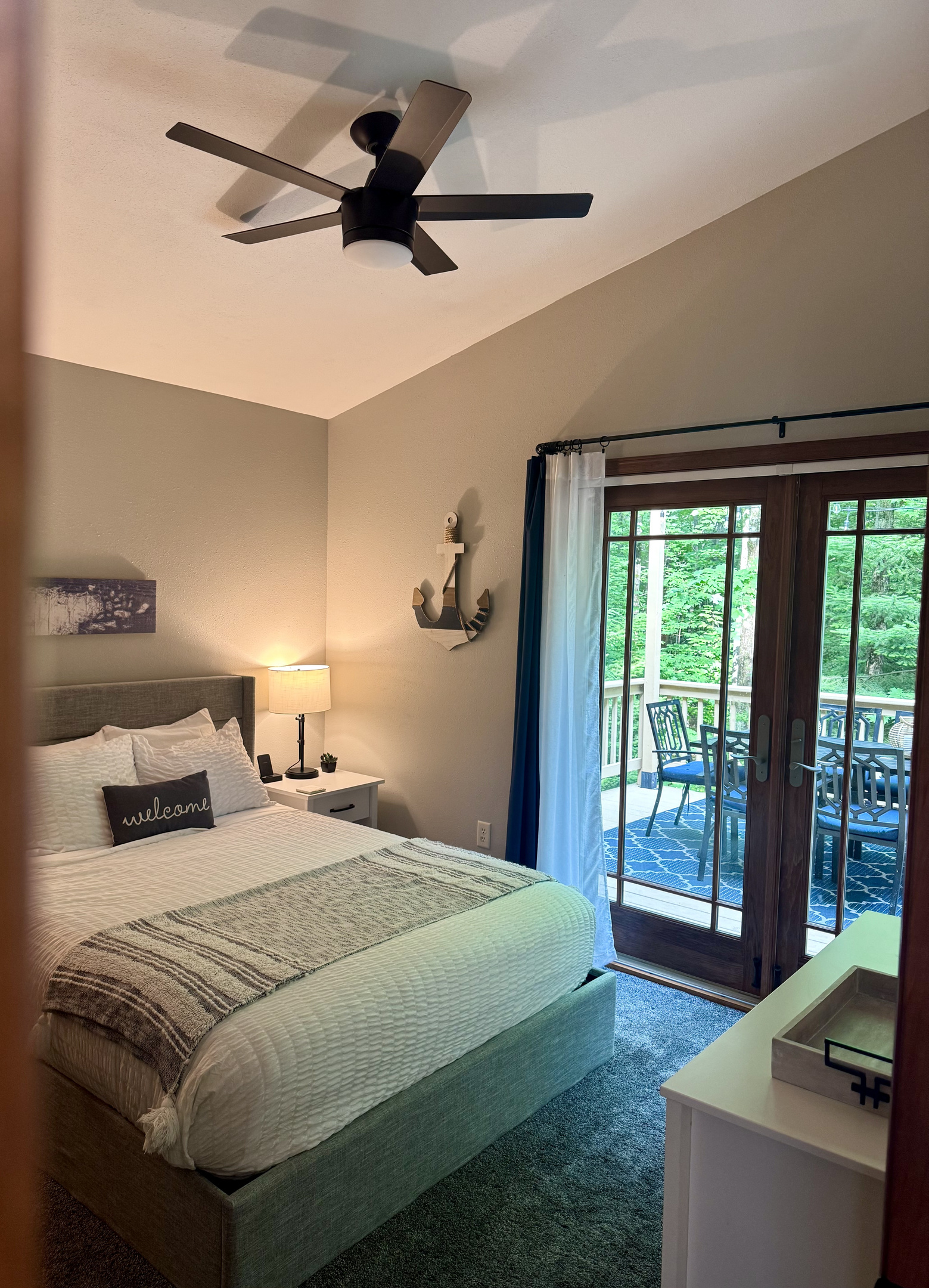 Main Cottage Bedroom view to back deck, with provided breakfast tray, two wireless phone charging stations. French doors plenty of light 