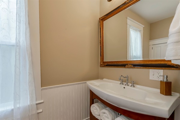 Freshen up in the main level bathroom just across from the Den. Complete with a vintage porcelain sink and luxurious towels. Includes a full tub and shower.