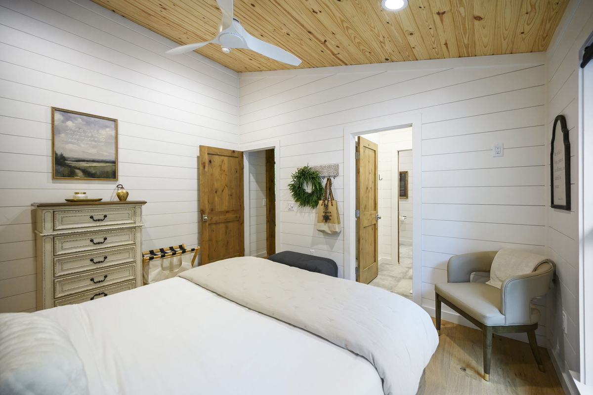 A beautifully appointed queen bedroom featuring luxury design, high-end linens, and peaceful forest views.