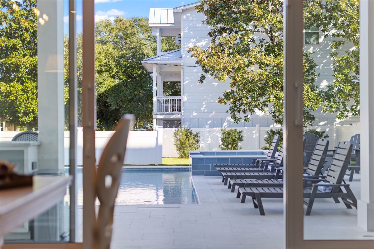 Double sliding glass doors overlooking the pool and back yard