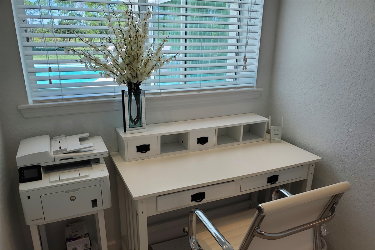 Separate office space with desk, chair and printer.  View of pool.