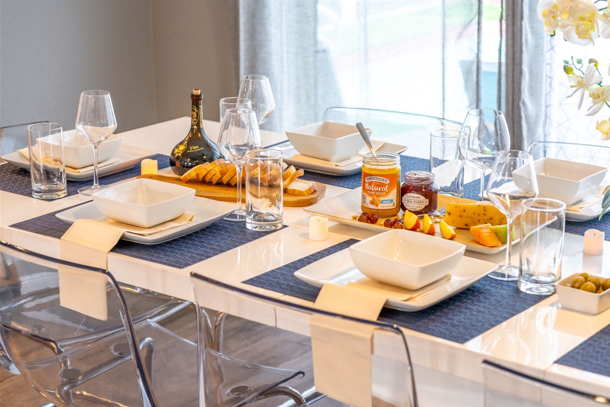 Set with minimalist décor and table settings for 10, this space is ideal for formal dinners or casual breakfasts alike.