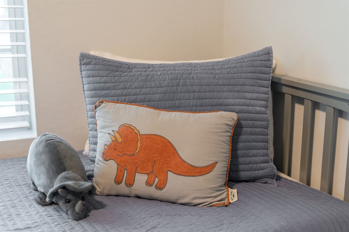 Fun bed pillows featuring a playful rhinoceros print, complemented by stylish accents for a unique touch to the room.