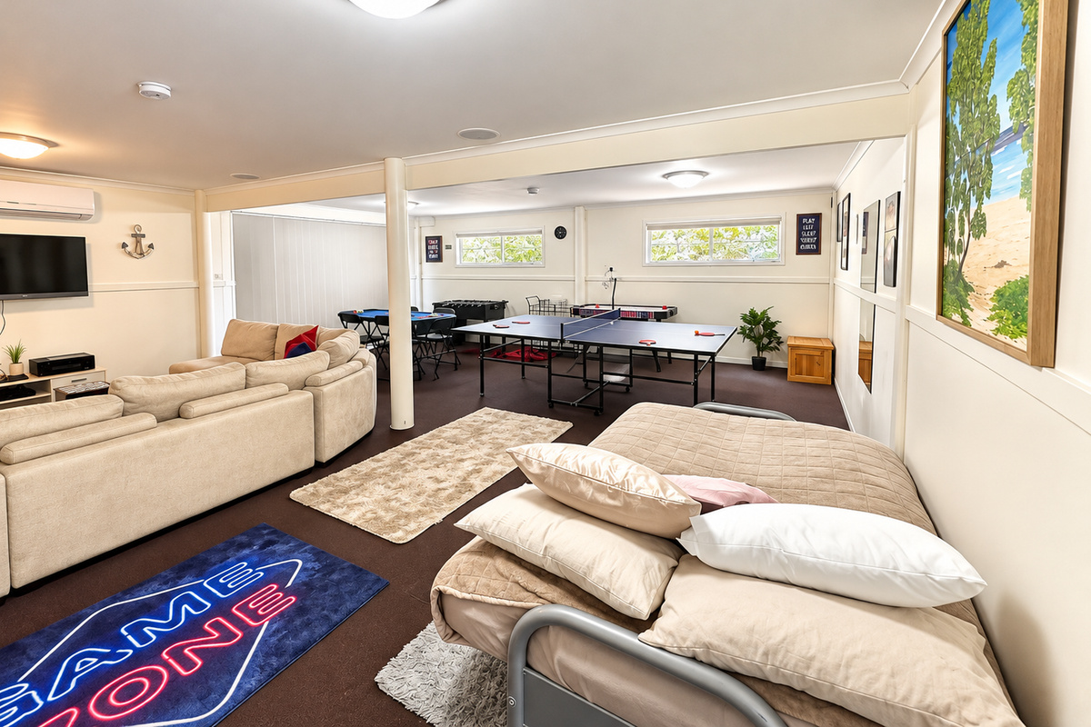 A spacious entertainment area at Carlenes Getaway, with comfortable lounge seating, a TV, table tennis and plenty of room to enjoy time together.