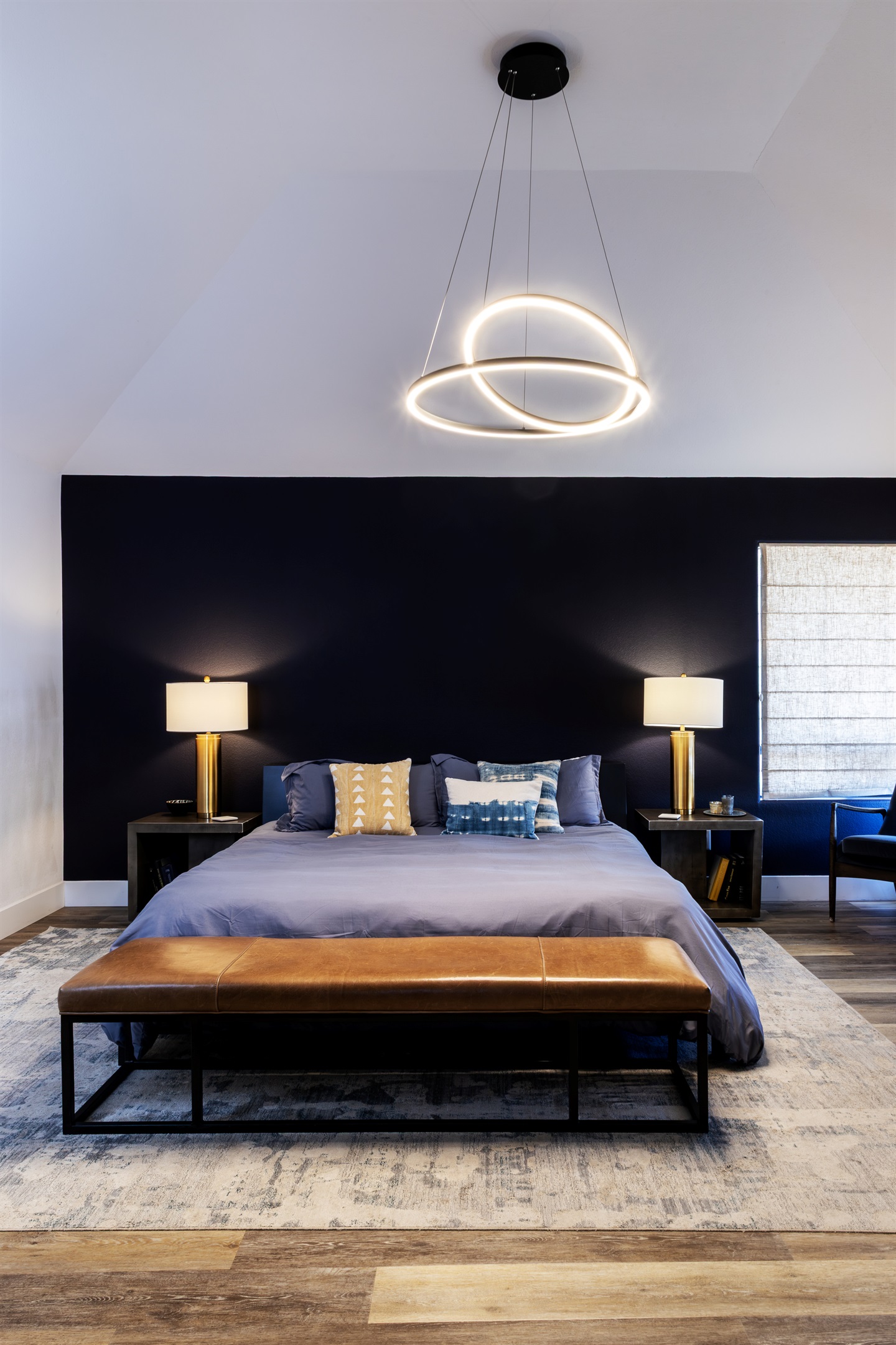The master suite — a sculptural pendant light, rich navy accent wall, and a king bed made for the deepest sleep. Pure indulgence at the top of the hill.