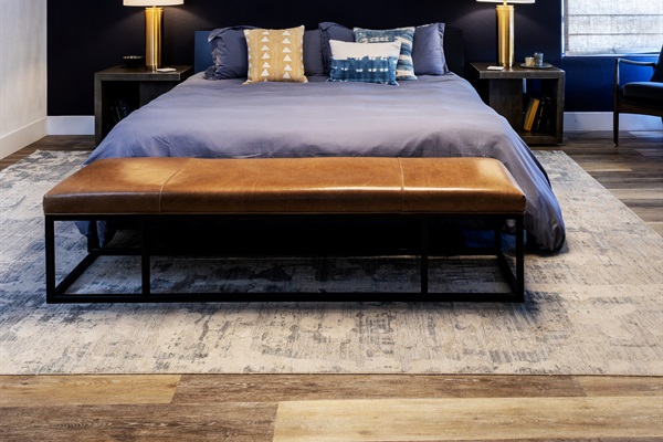 The master suite — a sculptural pendant light, rich navy accent wall, and a king bed made for the deepest sleep. Pure indulgence at the top of the hill.