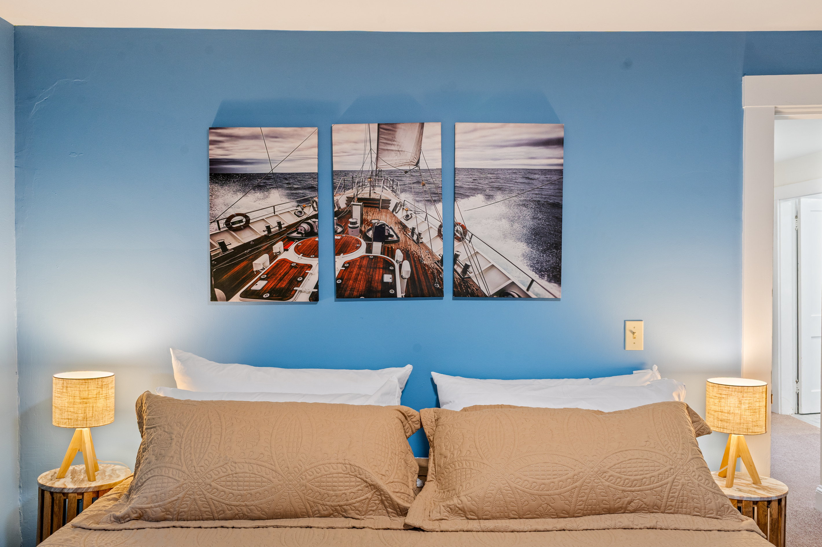 Resting your head back, the expansive canvas art of a ship cutting through the waves sets the perfect ocean tone for your stay. The soft glow of the matching bedside lamps provides an incredibly cozy atmosphere for late-night reading in bed.