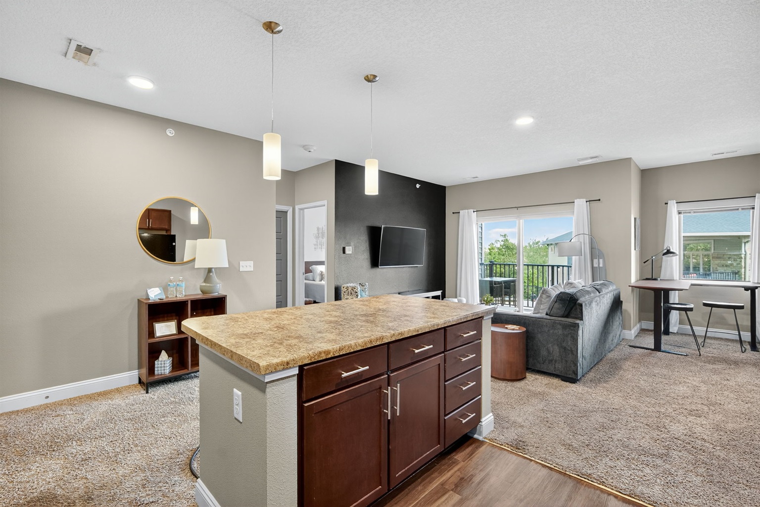 Step inside to an open-concept design with a full kitchen, spacious island, and modern pendant lighting. The island overlooks the living room and balcony, blending cooking, dining, and relaxing in one seamless space.