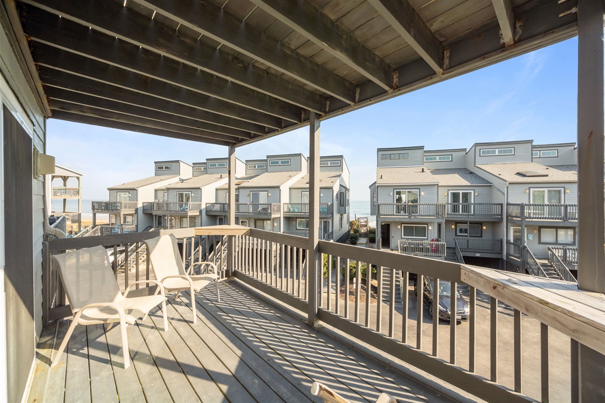 Covered balcony with comfortable seating and a relaxing vantage point toward the ocean